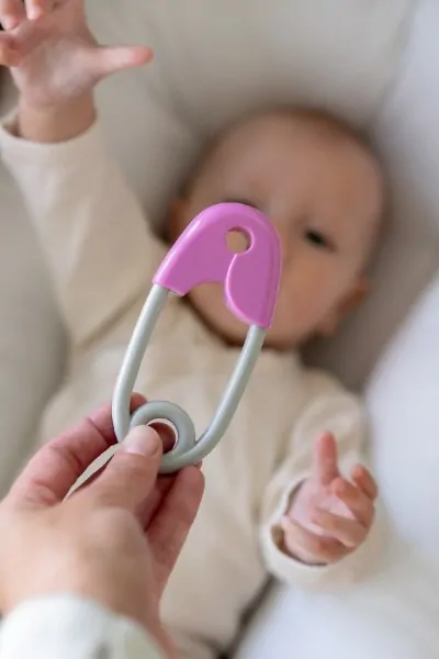  Chrastítko špendlík plast 12cm růžovošedé 12x19cm v sáčku 0m+