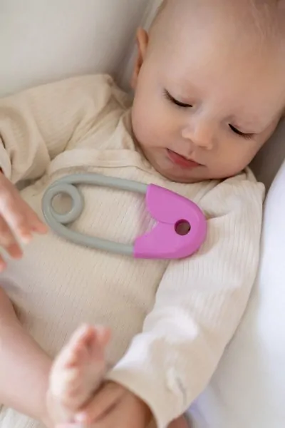  Chrastítko špendlík plast 12cm růžovošedé 12x19cm v sáčku 0m+